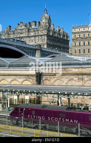 The Flying Scotsman debout à la gare de Waverley d'Édimbourg est à l'hôtel Balmoral à l'arrière-plan. Banque D'Images