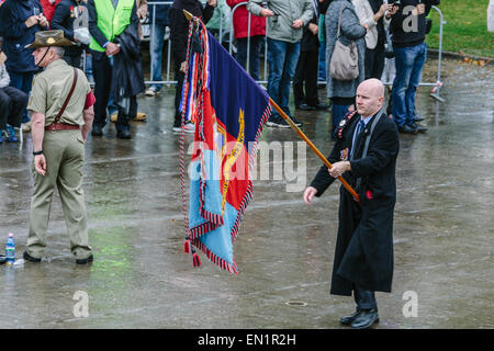 Melbourne, Australie. 25 avril 2015. Porte-drapeau (à droite) la réalisation d'un drapeau de Dunkerque avec anciens combattants soldat australien (à gauche). L'Anzac Day de mars et vétéran des militaires et leurs descendants, de Princes Bridge au culte du souvenir, par temps de pluie. L'Anzac Day de cette année marque le centenaire de l'atterrissage de Gallipoli ANZAC et soldats alliés en Turquie le 25 avril 2015. Banque D'Images