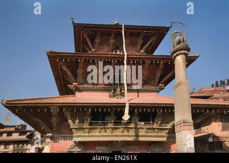 Le Népal, Katmandou, Patan, Durbar Square, Bhimsen Temple Hindou (reconstruite en 1682) avec Lion statue sur une colonne en premier plan Banque D'Images