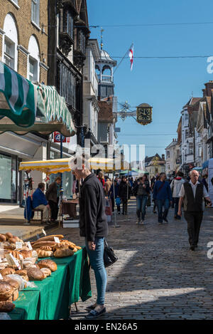 Le marché des fermiers mensuelles régulières sur le Guildford High Street avec un étal vendant du pain et des gâteaux dans l'avant-plan Banque D'Images