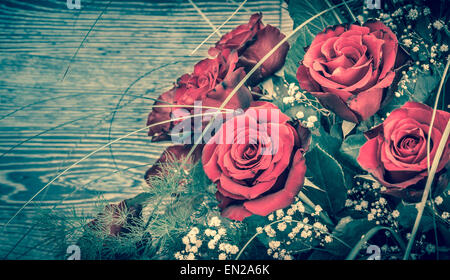 Belles roses rouges bouquet contre fond de bois Banque D'Images