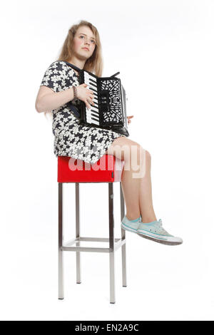 Teenage girl siège au tabouret rouge en studio avec backgroyund blanc contre l'accordéon Banque D'Images