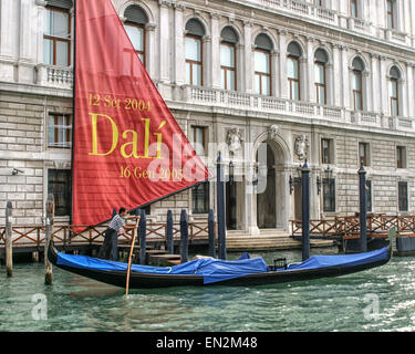 Venise, Province de Venise, Italie. 7 Oct, 2004. Un gondolier polonais sa gondole traditionnelle sur le Grand Canal passé une bannière annonçant une rétrospective Salvatore Dali au 18ème siècle du Palazzo Grassi museum. Situé sur la place Campo San Samuele, c'est le dernier palais construit sur le Grand Canal avant l'effondrement de la République de Venise en 1797. Venise, Site du patrimoine mondial de l'UNESCO, est l'un des plus populaires destinations touristiques internationales. © Arnold Drapkin/ZUMA/Alamy Fil Live News Banque D'Images