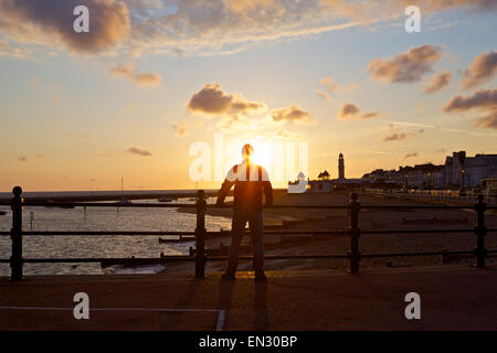 Herne Bay, Kent, UK. 27 avril 2015 : Météo France. Un homme regarde le lever du soleil à Herne Bay seafront, silhouetté contre le ciel tôt le matin. Après les averses de dimanche les prochains jours seront très bien dans le sud-est Banque D'Images