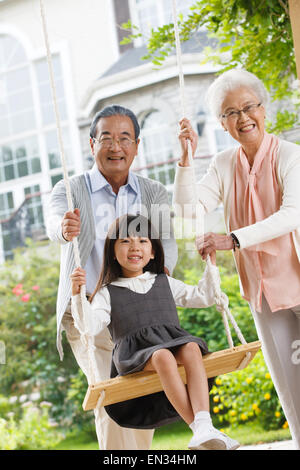 Grand-maman et grand-papa avec une petite petite-fille swing Banque D'Images