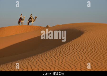 Les hommes sur des chameaux dans les dunes de Méroé, pharaons noirs, Nubia, Nil, au Soudan Banque D'Images
