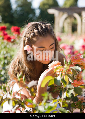 USA, Utah, Léhi, teenage girl (16-17) smelling flowers in garden Banque D'Images