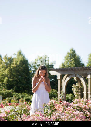 USA, Utah, Léhi, teenage girl (16-17) smelling flowers in garden Banque D'Images