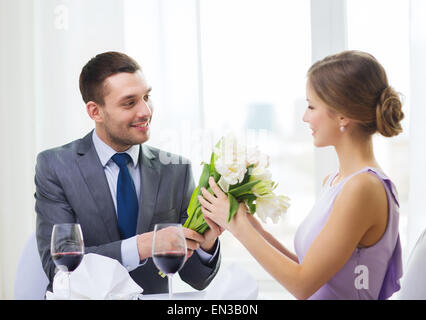 Smiling man giving bouquet au restaurant Banque D'Images