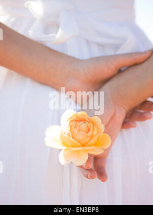 USA, Utah, Léhi, mid section of teenage girl (16-17) holding rose behind back Banque D'Images