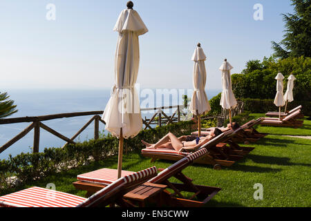 L'Italie, Ravello, Côte Amalfitaine, Couple de bronzer sur les chaises longues avec vue sur mer Banque D'Images