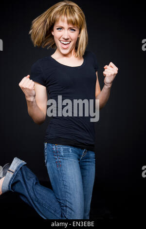 Studio shot of young woman cheering et décisions fists Banque D'Images