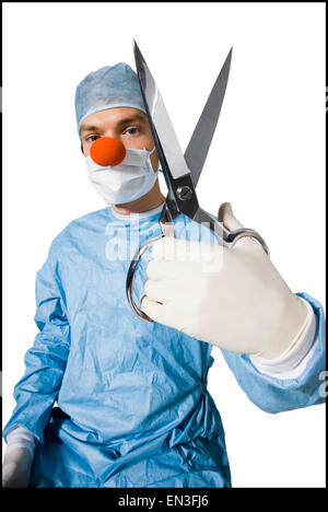 Chirurgien portant un nez de clown creepy et holding scissors Banque D'Images