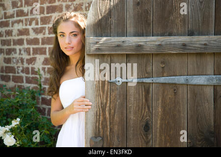 USA, Utah, Léhi, portrait of teenage girl (16-17) derrière la porte en bois Banque D'Images