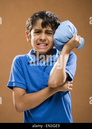 Boy holding ice pack à la tête Banque D'Images