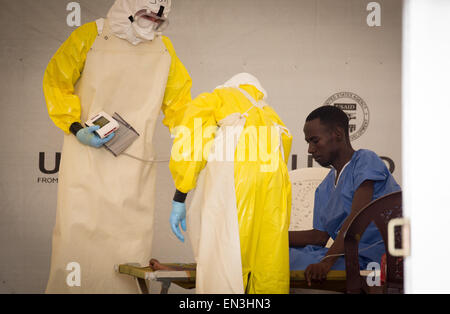 Monrovia, Libéria. Apr 9, 2015. Un homme est traité par deux membres du personnel portant des vêtements dans un hôpital de l'SITTU (infection grave de l'unité de traitement temporaire) à Monrovia, Libéria, 9 avril 2015. Photo : Kay Nietfeld/dpa/Alamy Live News Banque D'Images