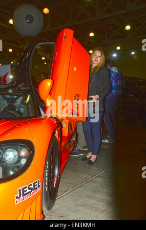 Moscow Tuning Show 2015 belle jeune fille posant à côté du visiteur de l'exposition avec une orange Saleen Banque D'Images