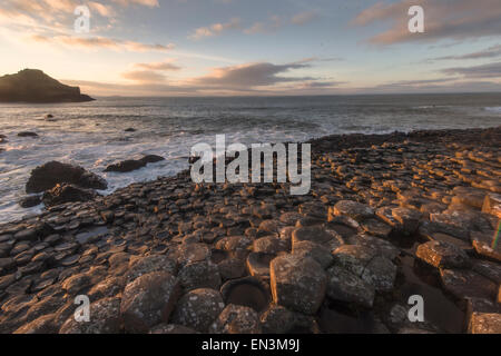 Membre du public prend une photographie de le coucher du soleil sur la Chaussée des géants dans le comté d'Antrim, sur la côte nord-est du Nord Banque D'Images