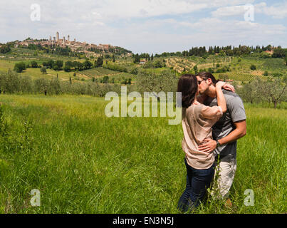 Italie, Toscane, San Gimignano, jeune couple kissing on meadow Banque D'Images