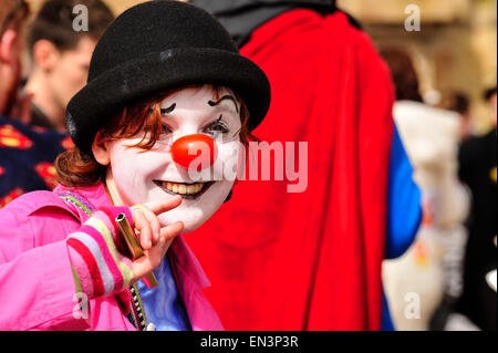 Clown avec blanc visage peint et nez rouge portant un chapeau dans le Guildhall Square, Derry, Londonderry, en Irlande du Nord. Banque D'Images