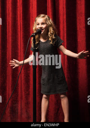 USA, Utah, Orem, Portrait of Girl (8-9) chantant avec microphone Banque D'Images