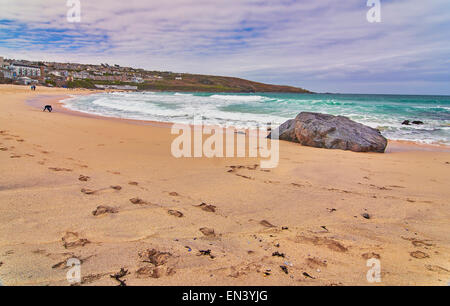 Vue de la plage à St Ives en Cornouailles avec des vagues se briser sur la plage de sable. Banque D'Images