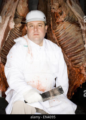 Butcher assis avec crochet de carcasses et de la viande Banque D'Images