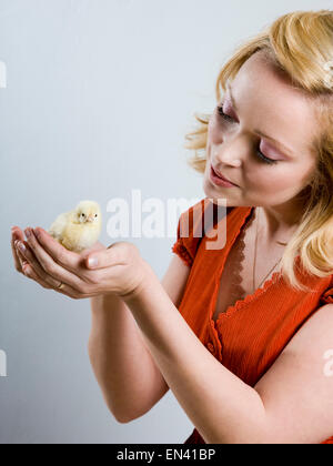 Woman holding a baby chick Banque D'Images