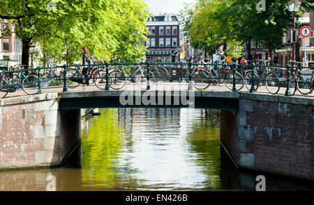 Prêt de vélos stationnés sur un pont sur un canal à Amsterdam, Hollande, Pays-Bas, Europe Banque D'Images