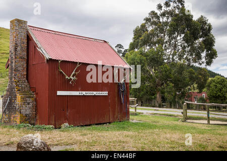 Cabane en tôle ondulée rouge avec cheminée en briques sur Petuna ferme, en Nouvelle-Zélande. Banque D'Images