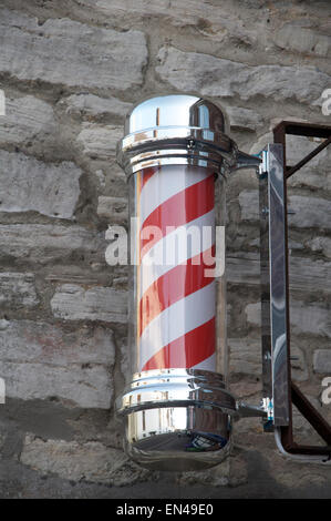 Le rouge et blanc à rayures helix d'un idéal féminin traditionnel. Fixé au mur au-dessus d'un gentlemen's hairdressers shop en Angleterre. United Kingdom. Banque D'Images