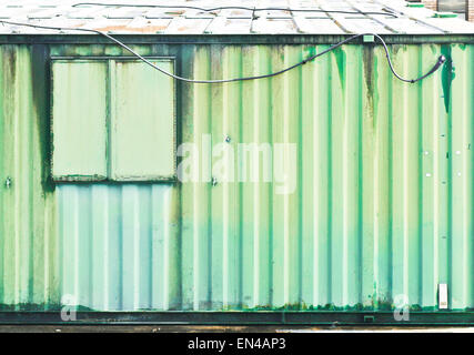 Métal ondulé vert rouillé sur l'extérieur d'un bâtiment industriel Banque D'Images