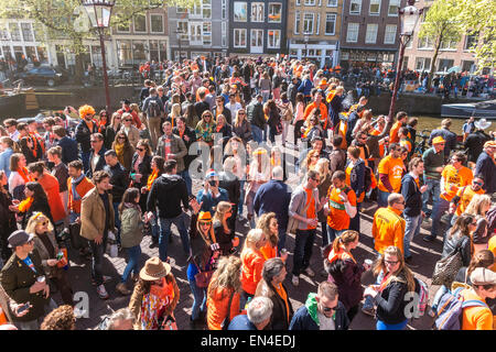 Des foules de gens sur un pont célèbre Koningsdag, Kings Day à Amsterdam le Canal Prinsengracht. Banque D'Images