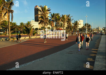 Des groupes de personnes à pied sur la promenade du bord de mer de Durban, Afrique du Sud pour faire de l'exercice de loisirs loisirs voyage paysages paysage urbain Banque D'Images