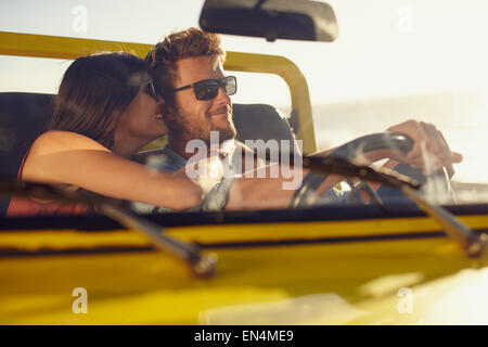 Jeune couple romantique partager un moment spécial pendant un voyage. Man driving car avec ma copine. Banque D'Images