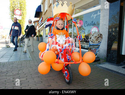 Voorschoten, Pays-Bas. 27, avril 2015. Une jeune fille est vu sur un vélo décoré en orange, la couleur nationale utilisé pour la célébration de l'Anniversaire du Roi. Credit : Jaap Arriens/Alamy Live News Banque D'Images