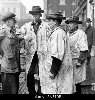 Bela Zola dans le miroir de la vie série. Trois poissons porter porter leur service de chapeaux à Billingsgate Fish Market dans l'East End de Londres discuter du commerce. 28 février 1954. Banque D'Images