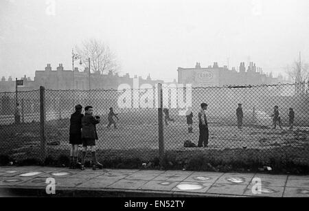 La vie dans le miroir Notre Gang. 19 janvier 1954 Les garçons jouent au football sur vu par d'autres sur une bombe site off road Bow dans l'East End de Londres Banque D'Images