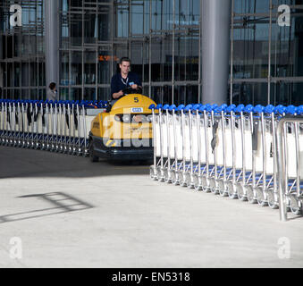 L'homme conduisant le véhicule la collecte des chariots à l'aéroport de Malaga, Espagne Banque D'Images