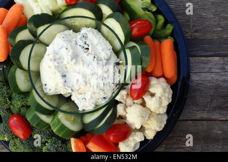 Assiette de crudités et trempette sur de vieilles planches en bois Banque D'Images