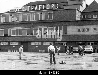 Un groupe de jeunes garçons jouent un jeu de cricket à l'extérieur d'Old Trafford, la masse des cendres en vue de la prochaine 4e test match entre l'Angleterre et l'Australie. 22 juillet 1964. Banque D'Images