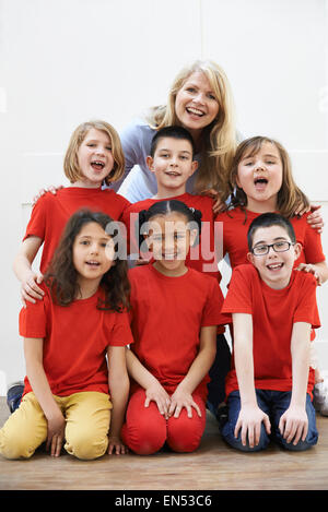 Groupe d'enfants avec l'enseignant bénéficiant d'atelier d'Art Dramatique Ensemble Banque D'Images