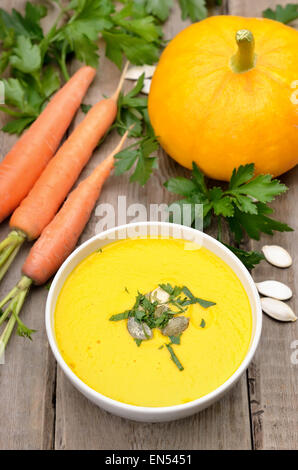 Bol à soupe de potiron et de légumes frais sur la table rustique Banque D'Images