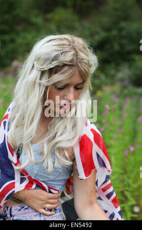 Belle jeune femme en bonne santé à l'extérieur portant tenue décontractée enveloppé dans une union jack flag Banque D'Images