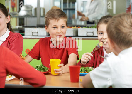 Groupe d'élèves assis à table dans la cafétéria de l'école Repas de l'alimentation Banque D'Images