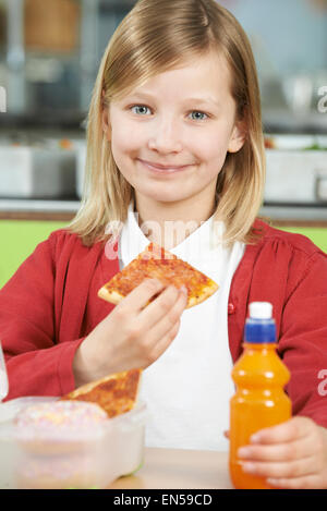 Girl Sitting At Table In School Cafeteria malsain de manger des paniers-repas. Banque D'Images