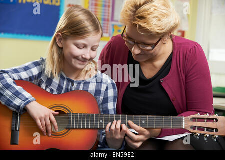 Aider l'enseignant élève à jouer de la guitare en Leçon de Musique Banque D'Images