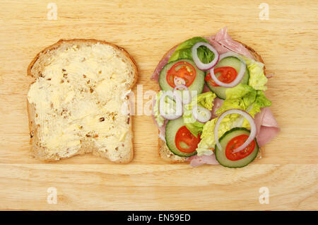 Deux moitiés d'un sandwich à la salade de jambon sur une planche en bois Banque D'Images