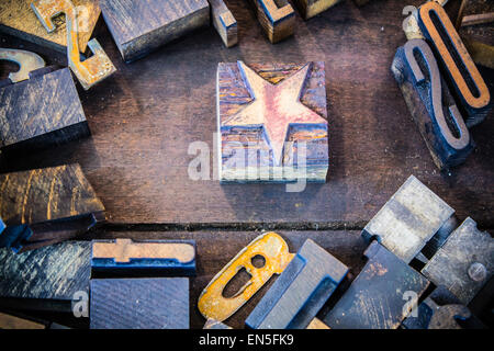 Une typographie vintage star entourée de bois et de métal rouillé de lettres et de chiffres dans un bac d'impression en bois sale Banque D'Images