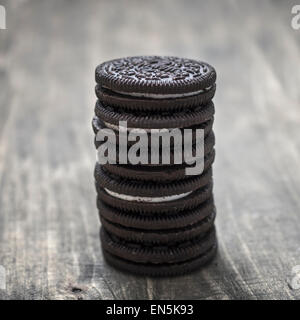 Les cookies au chocolat malsaine avec la crème vanille sur table Banque D'Images